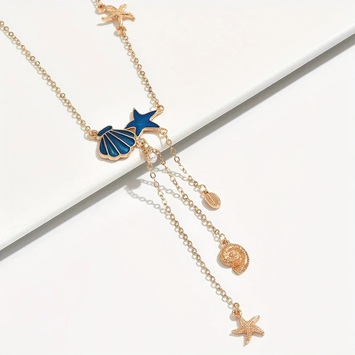 « Élégant collier en or avec une étoile et un « coquillage bleu » » pourrait être reformulé ainsi : « Collier en or raffiné avec un pendentif en forme d'étoile et un coquillage bleu »