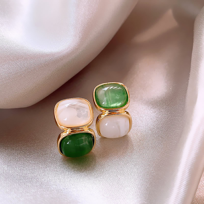 Élégantes boucles d'oreilles pendantes dorées ornées de pierres précieuses blanches et vertes
